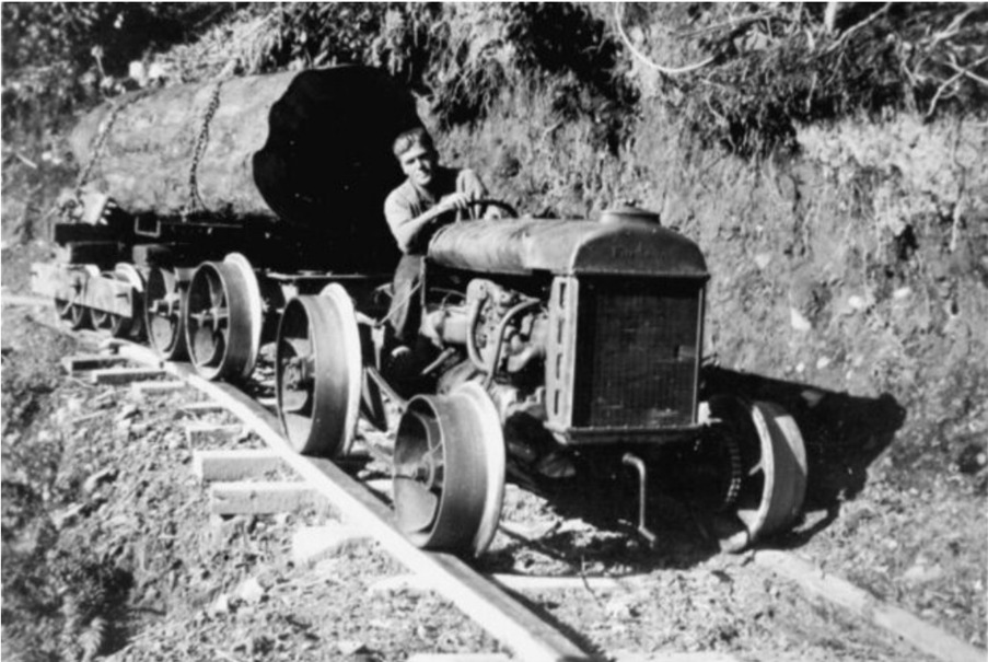 Bush tramway with tractor pulling log on wagon on wooden rails. Otaki Forks New Zealand 1930. Example of facing strategic challenges. Alexander Turnbull Library Ref: 1/2-059940-F